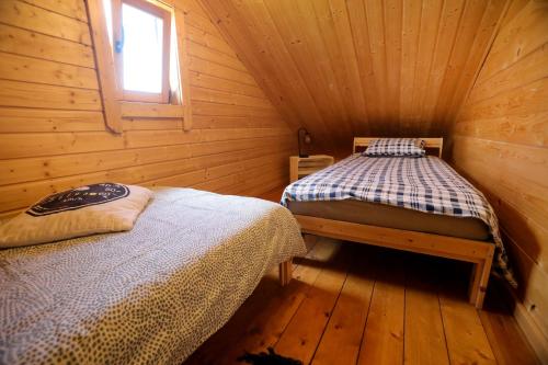 a bedroom with two beds in a wooden cabin at Domek Całoroczny Powidz tel 512-589-997 in Powidz