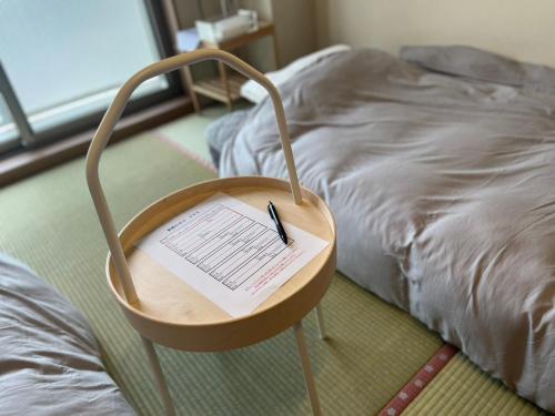 a chair with a piece of paper on it next to a bed at 東横のヨコ in Okayama
