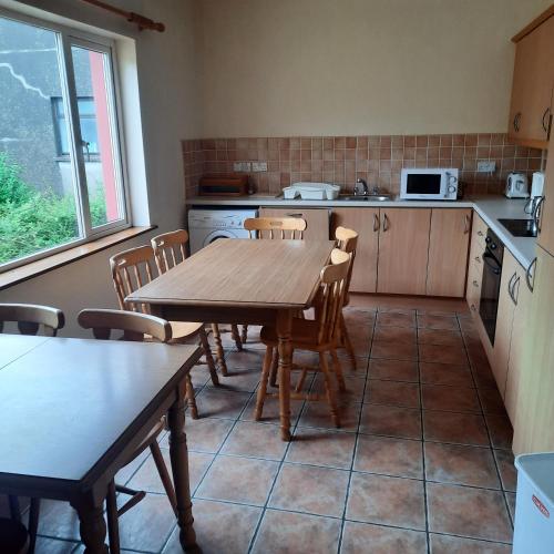 a kitchen with a wooden table and chairs in it at Star Outdoor Apartments in Kenmare