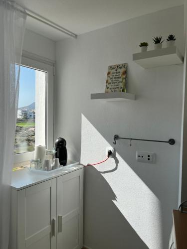 uma cozinha branca com um lavatório e uma janela em Casa Estefania em Sucina