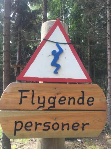 a sign on a wooden post with a blue arrow at In the middle of Trysil fjellet - Welcome Center - Apartment with 4 bedrooms and sauna - By bike arena and ski lift in Trysil