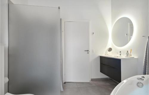 ein weißes Badezimmer mit einem Waschbecken und einem Spiegel in der Unterkunft Lovely Home In lbk With House A Panoramic View in Ålbæk