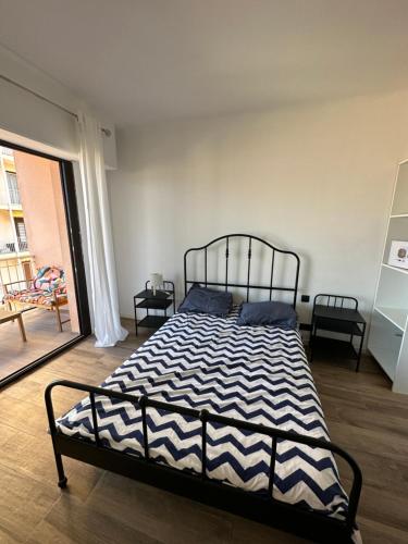 Schlafzimmer mit einem Bett mit einer schwarzen und weißen Bettdecke in der Unterkunft parc lazaro in Ajaccio