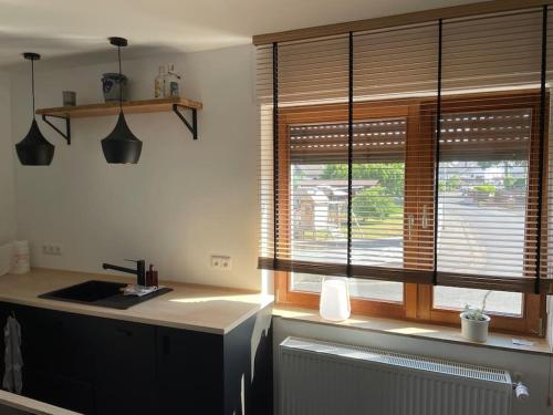 a kitchen with a sink and a window with blinds at Schönes Haus in der Wetterau in Utphe