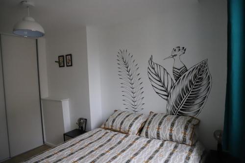 ein Schlafzimmer mit einem Bett mit einem Vogelbild an der Wand in der Unterkunft Le 23 de Louis in Limoges