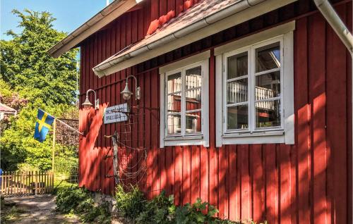 a red house with two windows on the side of it at Awesome Home In Torsö With Kitchen in Brommösund