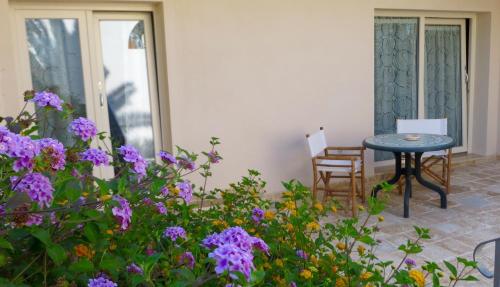 a patio with a table and some purple flowers at Villa Bruno in Maruggio