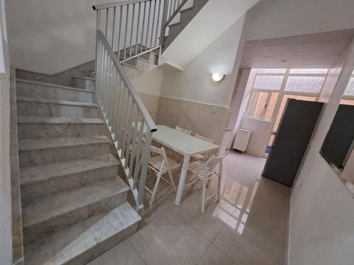 a dining room with a table and stairs in a house at No18 Cospicua in Cospicua