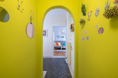 a hallway with yellow walls and an archway at Sweet home in Koukaki in Athens