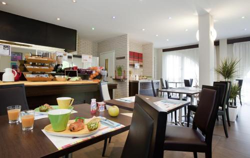 a kitchen and dining room with a table and chairs at ibis Styles Belfort Centre in Belfort