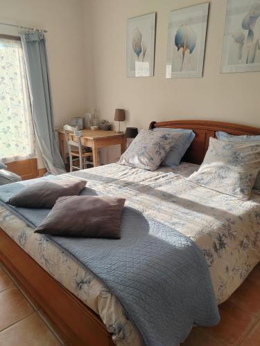 une chambre avec un grand lit avec des oreillers dessus dans l'établissement Chambres d' Hôtes des Glands ' heures, à Saint-Martin-de-Gurçon