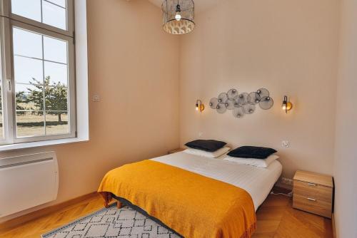 にあるDomaine Grand Piquecaillou - Appartement Pessac Leognanのベッドルーム1室(黄色い毛布と窓付)