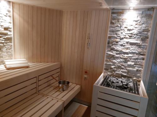 a sauna with a bench and a stone wall at Morada Hotel Alexisbad in Alexisbad