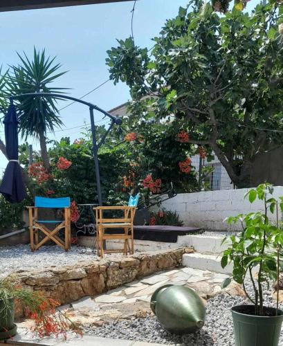 two chairs and a table in a garden at PARADISE in Dhaskalión