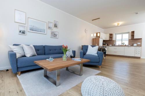 a living room with a blue couch and a table at Ferienwohnung Jonte in Sassnitz