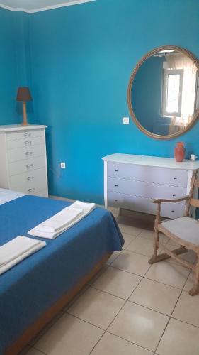 a blue bedroom with a bed and a mirror at PARADISE in Dhaskalión
