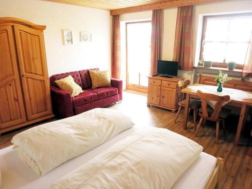 a living room with a bed and a table and a couch at Ferienhof Landhaus Michael in Böbrach