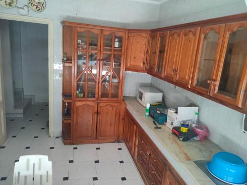 a kitchen with wooden cabinets in a room at Jardine Al Andalous in Tangier