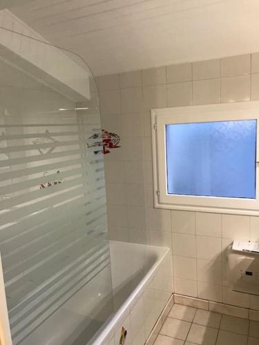 une salle de bain avec une baignoire et une fenêtre dans l'établissement Maison 3 chambres - Chez Florence, à Yzeure