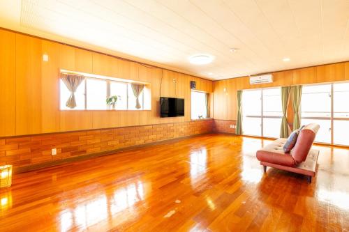 a living room with a chair and a television at えびす家 in Ishigaki Island