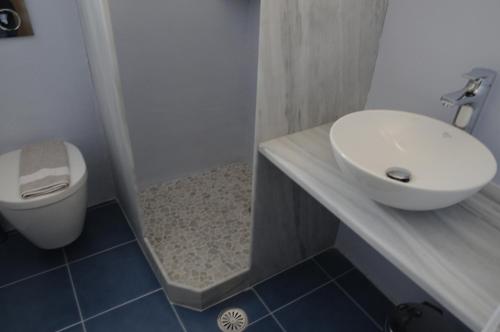 a bathroom with a white sink and a toilet at Andriani's Guest House in Mýkonos City