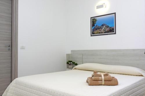 - une chambre blanche avec un lit et un porte-monnaie dans l'établissement GEMMA DEI 2 MARI, à Cinquefrondi
