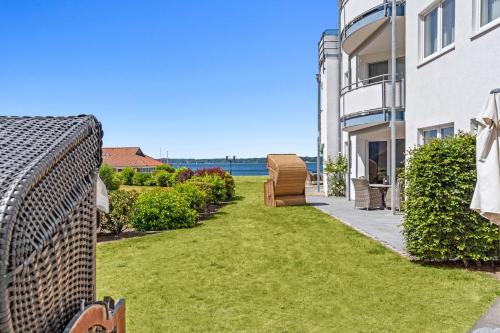 a backyard with grass and a view of the ocean at Strandhotel Glücksburg in Glücksburg