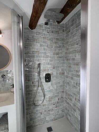 a shower in a bathroom with a brick wall at Can Jan Vives in Vidreres