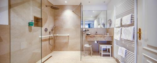 La salle de bains est pourvue d'une douche et d'un lavabo. dans l'établissement Fitschen am Dorfteich, à Wenningstedt