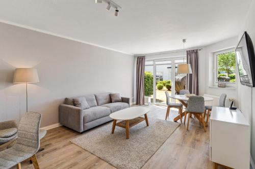 a living room with a couch and a table at Strandhotel Glücksburg in Glücksburg