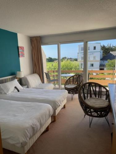 een hotelkamer met 2 bedden en een balkon bij Hôtel de la Pointe de Mousterlin in Fouesnant