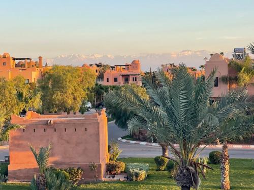 a view of a city with a palm tree and buildings at La Villa 2A in Marrakesh
