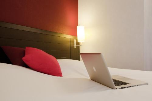 a laptop computer sitting on top of a bed at ibis Styles Belfort Centre in Belfort