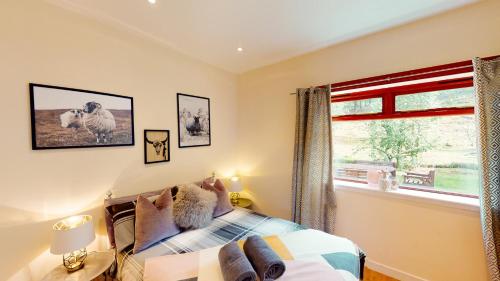- une chambre avec un lit et une fenêtre dans l'établissement Druim An Lochain Cottage, à Kinrara