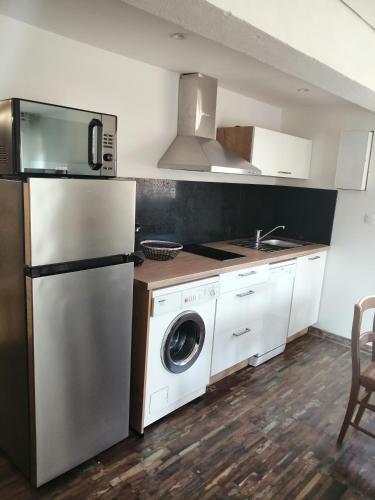 une cuisine avec un réfrigérateur et une machine à laver dans l'établissement Villa portiragnes, à Portiragnes