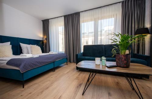 um quarto com uma cama, um sofá e uma mesa em Aparthotel InPoint Cracow G15 - Free Underground Parking em Cracóvia