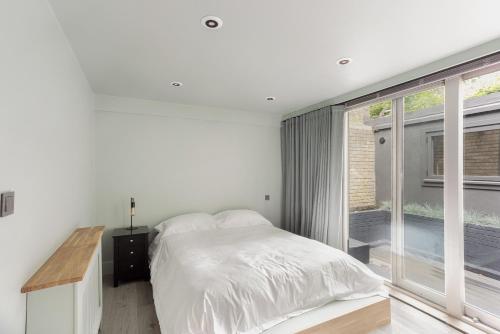 a bedroom with a bed and a large window at 189A Caledonian Road, London, N1 0SL in London