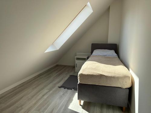 a bedroom with a bed and a skylight at Apartamenty Przy Deptaku in Świnoujście