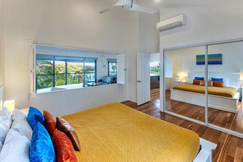 - une chambre avec un lit et une grande fenêtre dans l'établissement Heliconia 10 Newly Renovated Centrally Located House Hamilton Island, à Île Hamilton