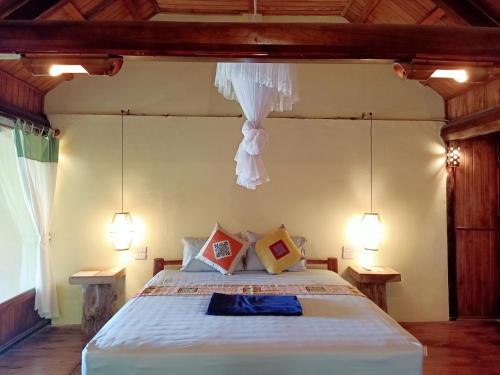 a bedroom with a large bed with two lamps at Puluong Home in Pu Luong