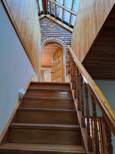 a staircase with wooden steps and a brick wall at Courtlyguesthouse in Witbank