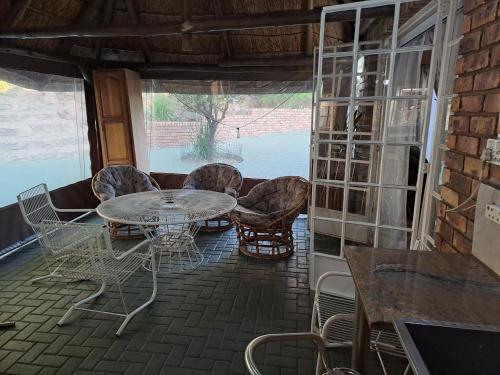 a patio with a table and chairs and a window at Courtlyguesthouse in Witbank