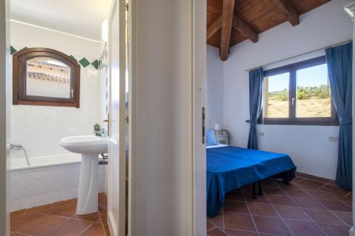 a bathroom with a bed and a sink and a tub at Villa Giada in Stintino