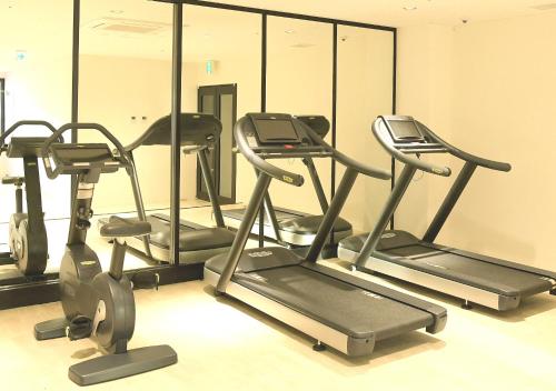 a gym with three exercise bikes and mirrors at Oriental Hotel Fukuoka Hakata Station in Fukuoka