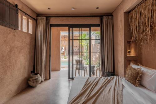 a bedroom with a bed and a door to a patio at Abu X Abu in Canggu