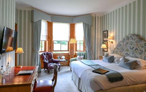 a hotel room with a large bed and a desk at The Jockey Club Rooms in Newmarket