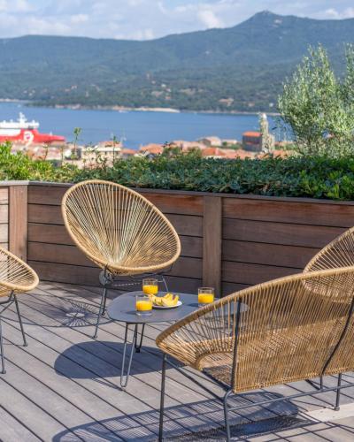 a patio with three chairs and a table with drinks on it at Résidence U Frusteru in Propriano