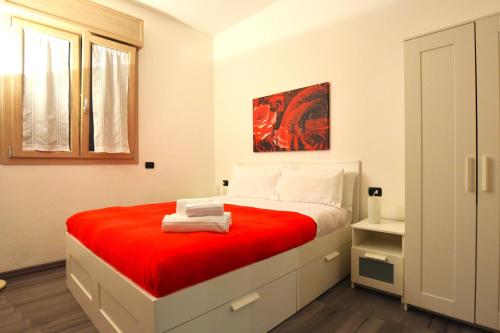 1 dormitorio con 1 cama grande con manta roja en Harmony Sirmione - Affitti Brevi Italia, en Sirmione