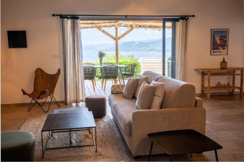 a living room with a couch and a large window at Résidence U Frusteru in Propriano