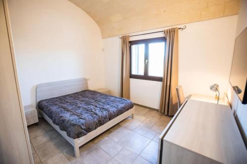 - une petite chambre avec un lit et une fenêtre dans l'établissement Lamia del carrubo, à San Vito dei Normanni